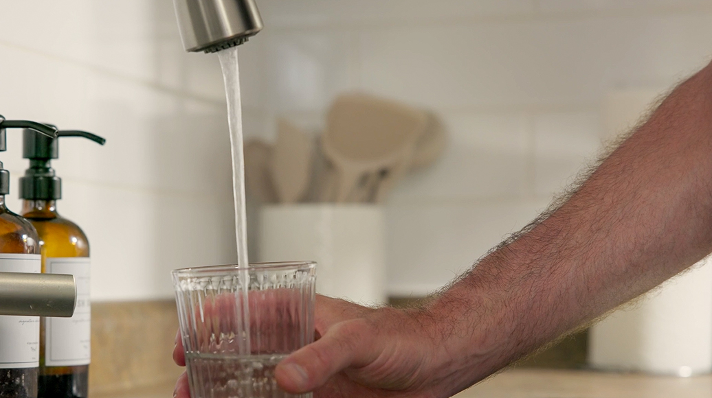 Person filling a cup with tap water