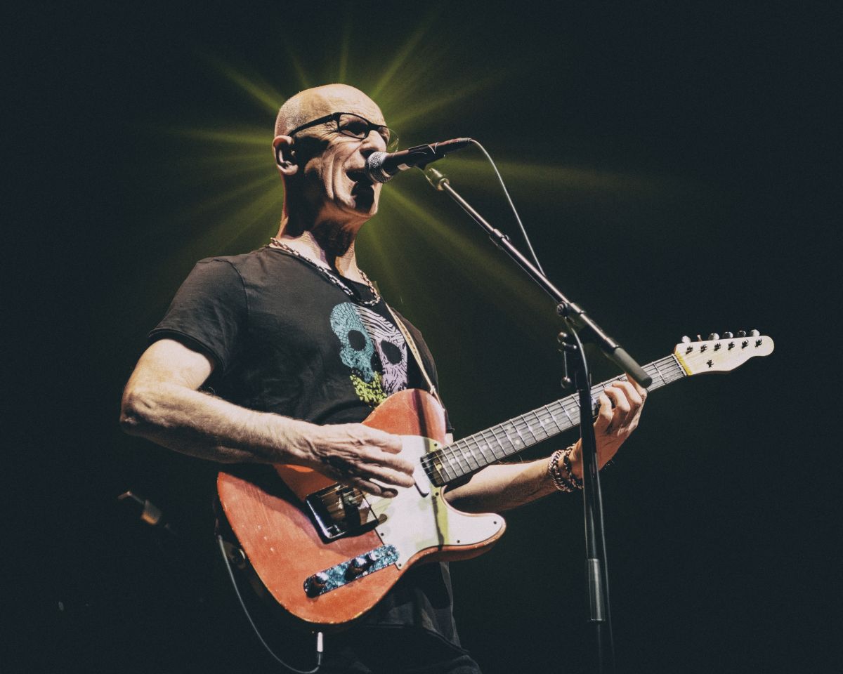 Person playing guitar and singing into microphone