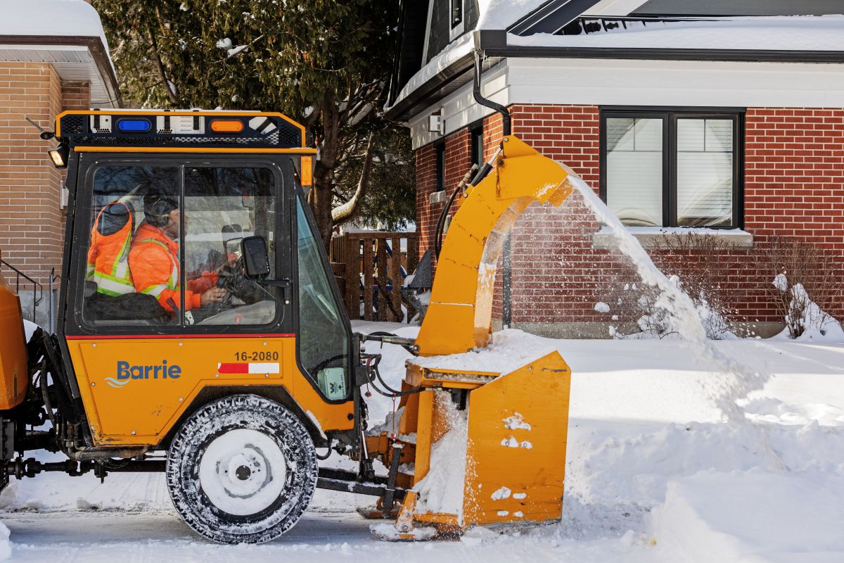 Person in City of Barrie snowblower removed snow from a sidewalk.