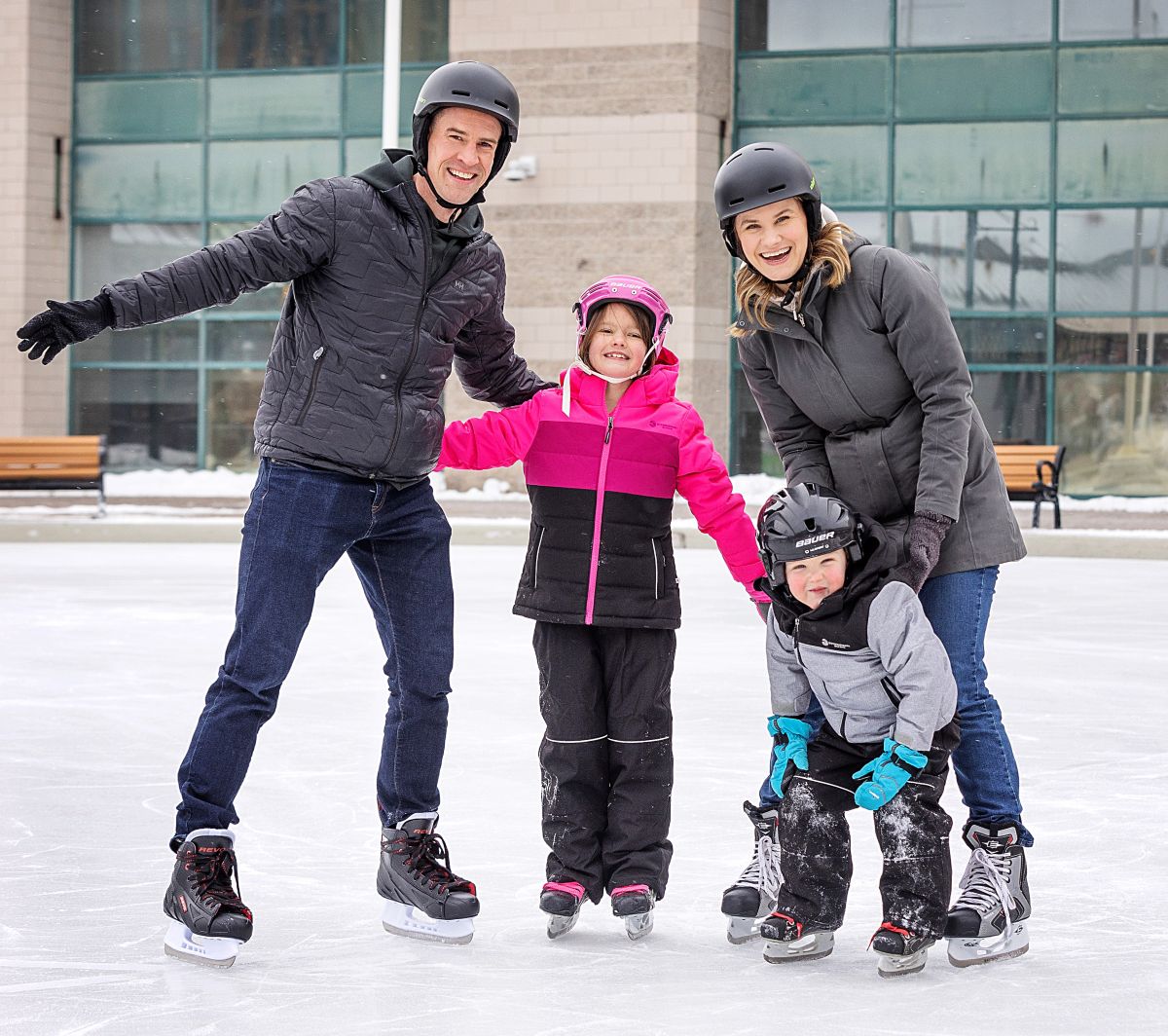 Family smiling and skating at Barrie City Hall.