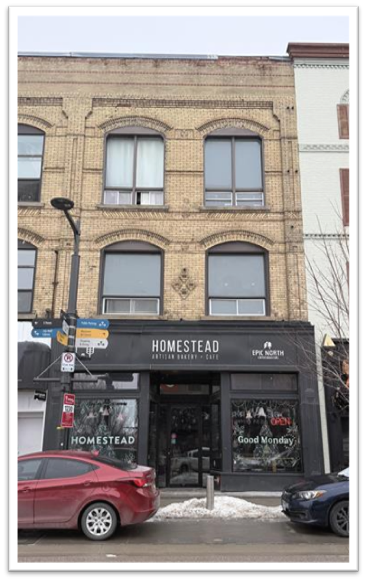 Three-story brick building with Homestead Bakery on the ground level.