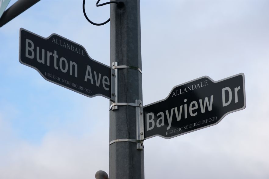 Street signs for Burton Avenue and Bayview Drive at a street corner.