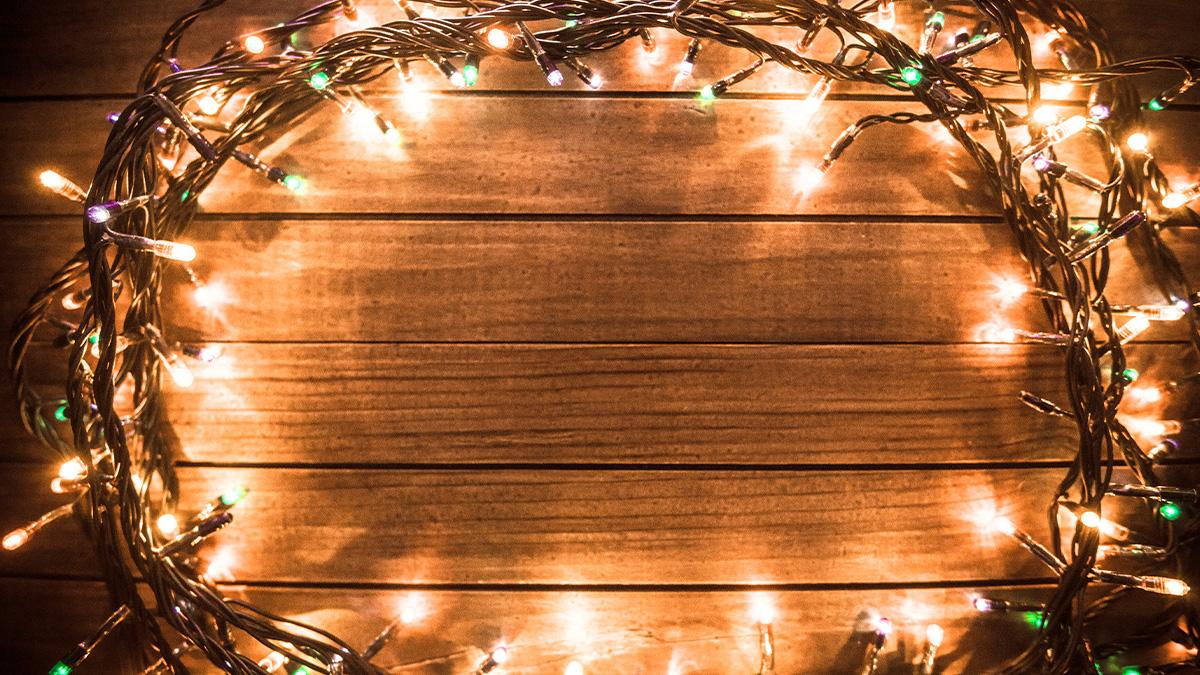 A circle of festive lights framing a slatted wooden wall