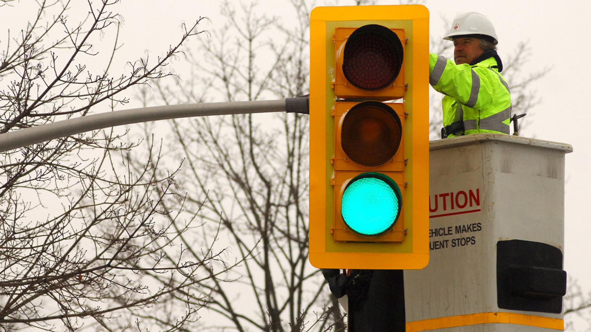 Traffic signal with green light, worker in bucket