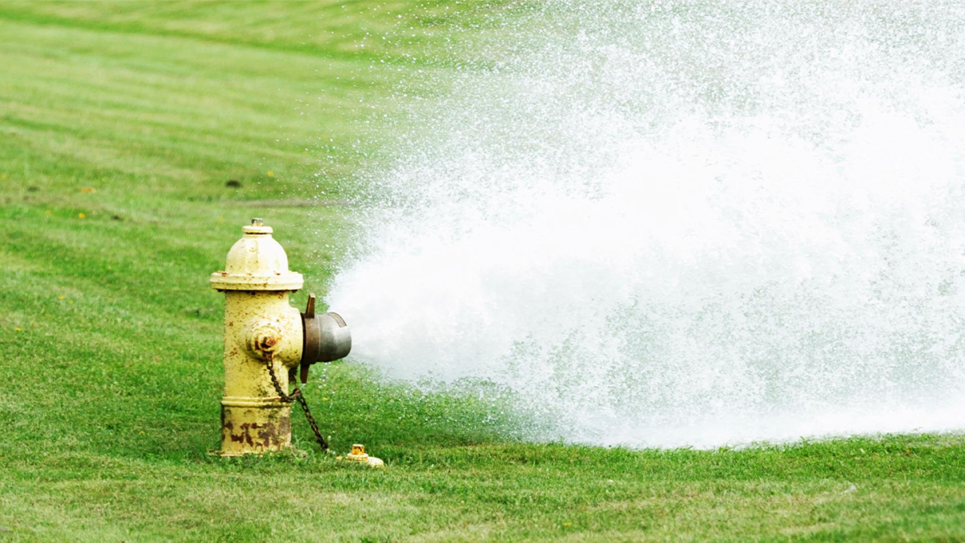 water flushing from yellow fire hydrant