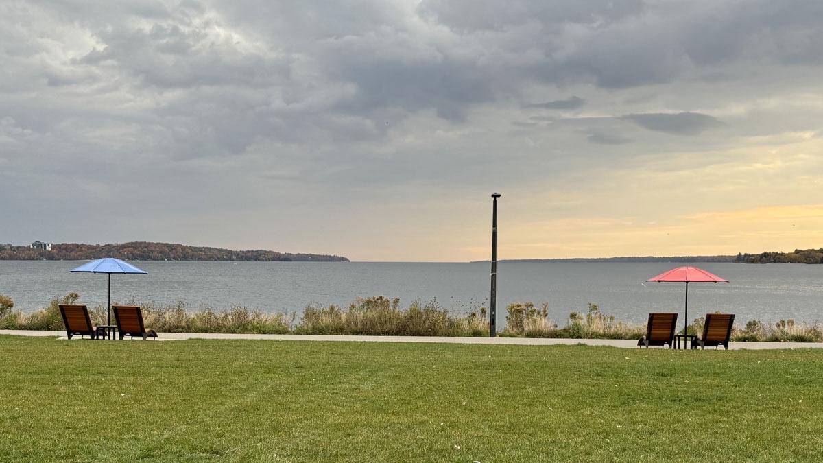 Facing Kempenfelt Bay on Barrie's waterfront, chairs and umbrellas in foreground