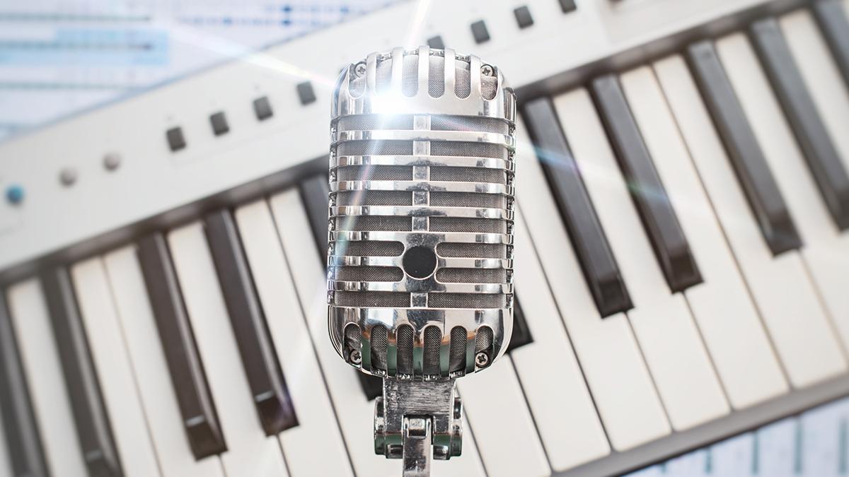 Retro microphone with piano keys and sheet music in background