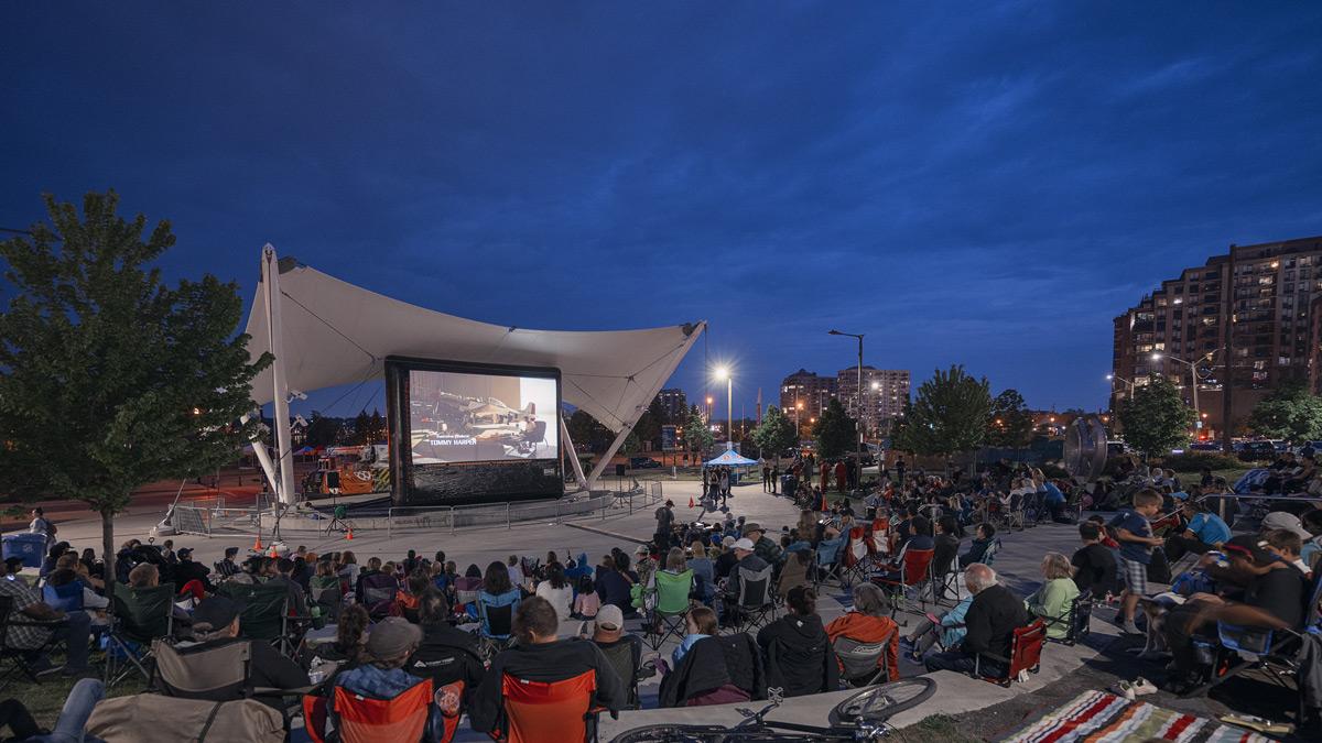 Crowd gathers for an outdoor movie screening at Meridian Place