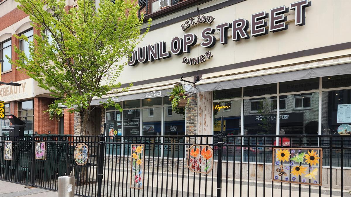 Colourful artwork of flowers on the Dunlop Street Diner patio fencing