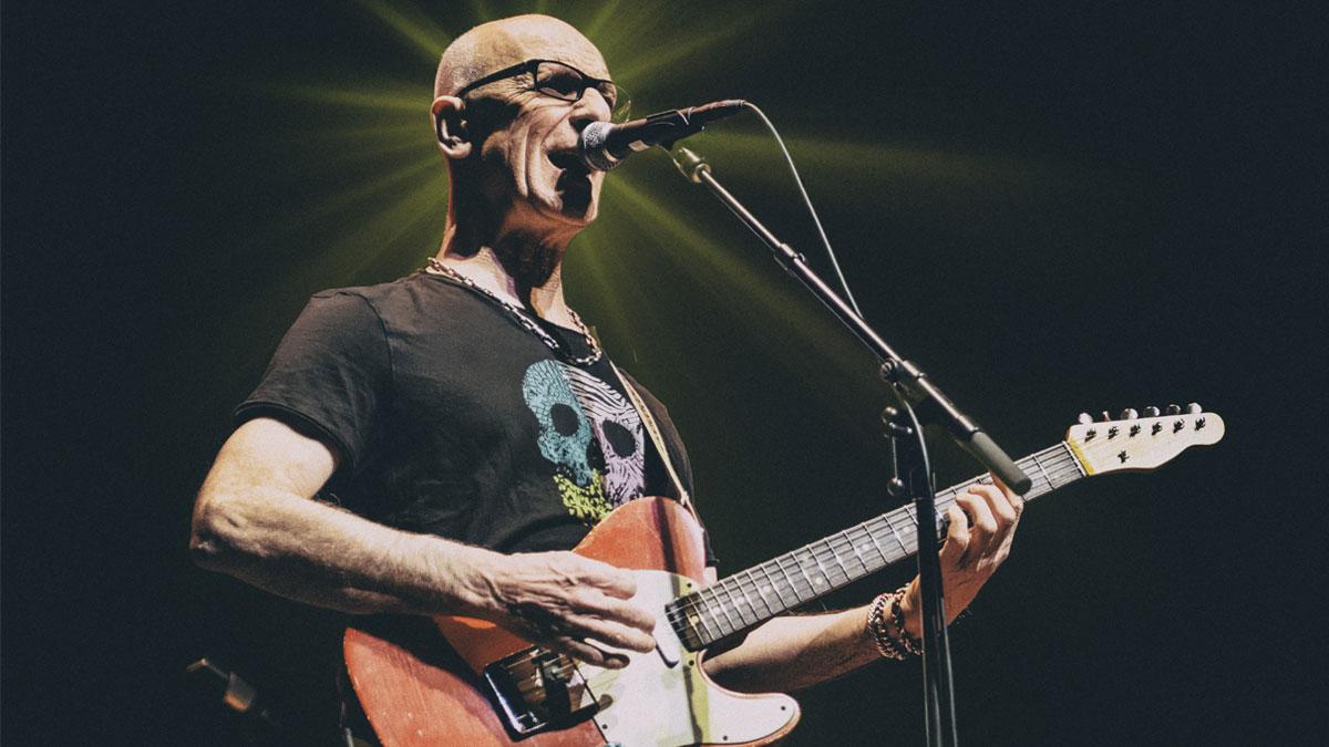 Person playing guitar and singing into microphone