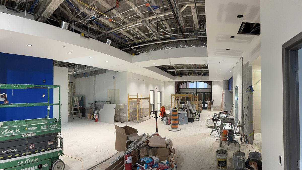 A construction site with exposed ceiling, tools, and building materials scattered.