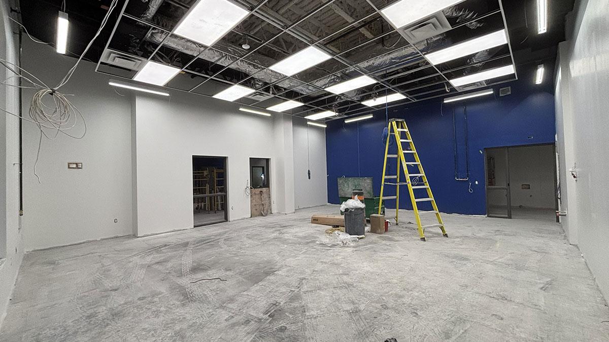 Construction site with a blue wall. Ceiling lights under construction.