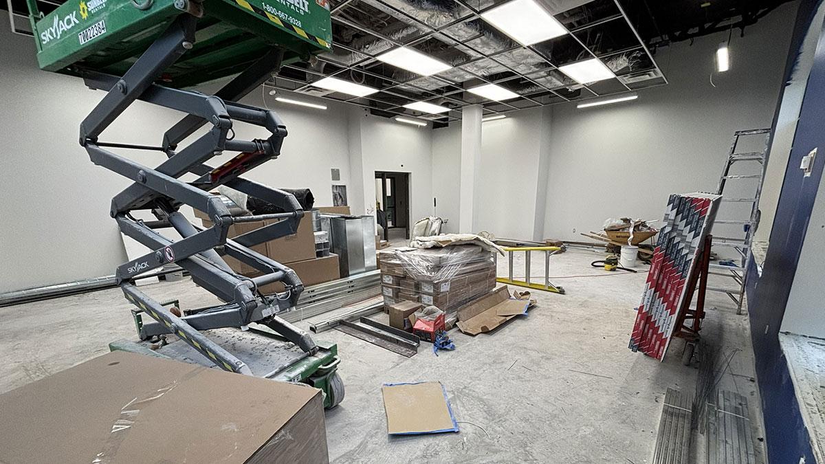 Construction site with scissor lift, materials, and tools.