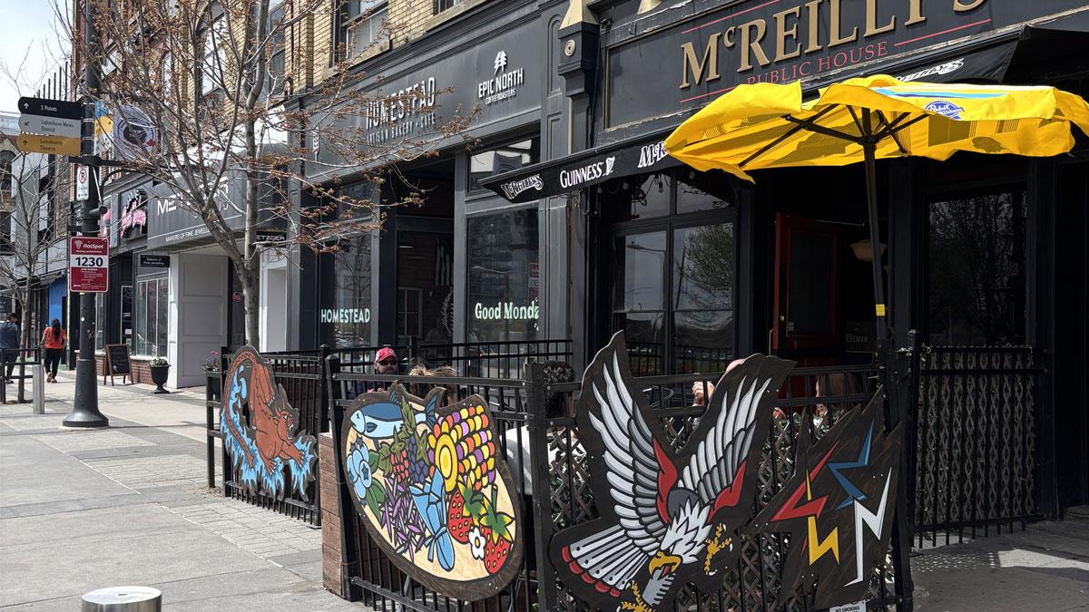 Outdoor view McReilly's with colorful artwork on the patio fence.