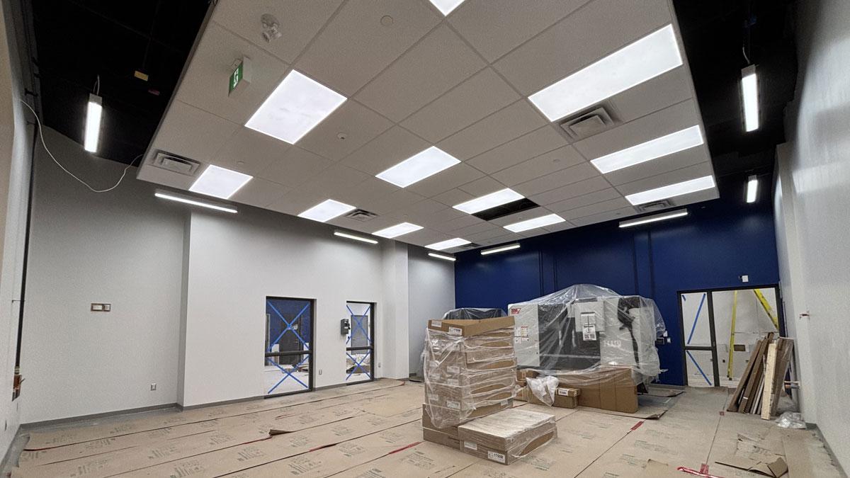 Empty interior under construction, featuring blue walls and stacked materials.
