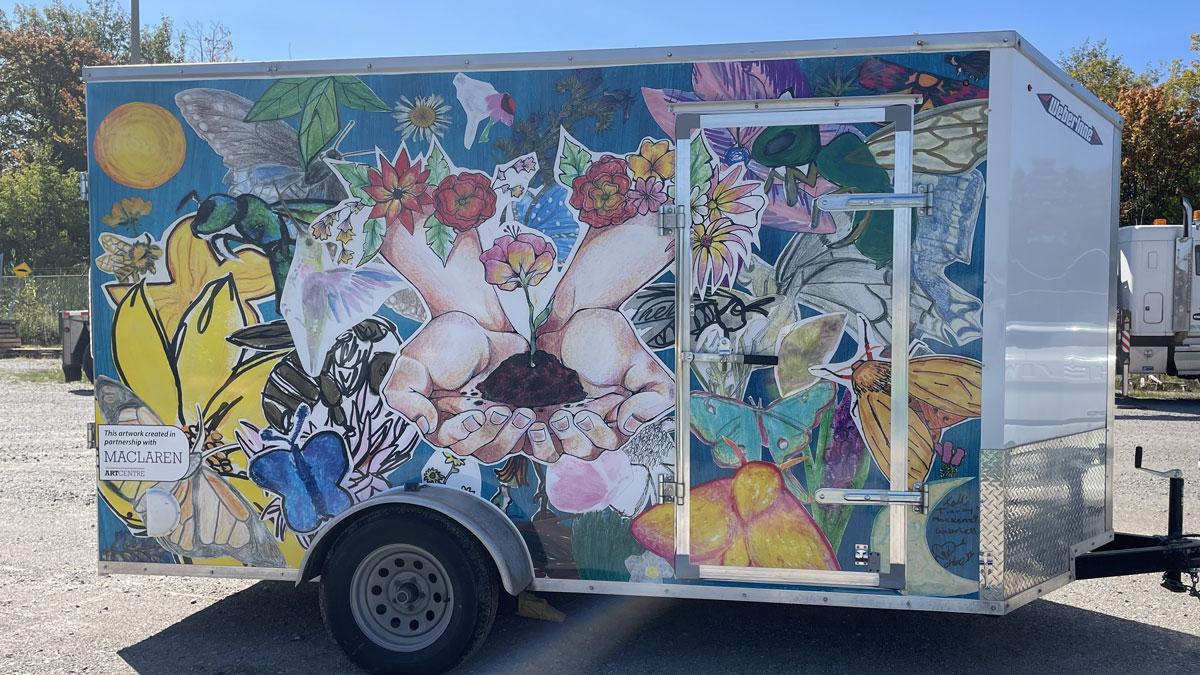 Colourful artistic mural (created in partnership with MacLaren Art Centre) on a trailer featuring flowers, butterflies and whimsical elements.