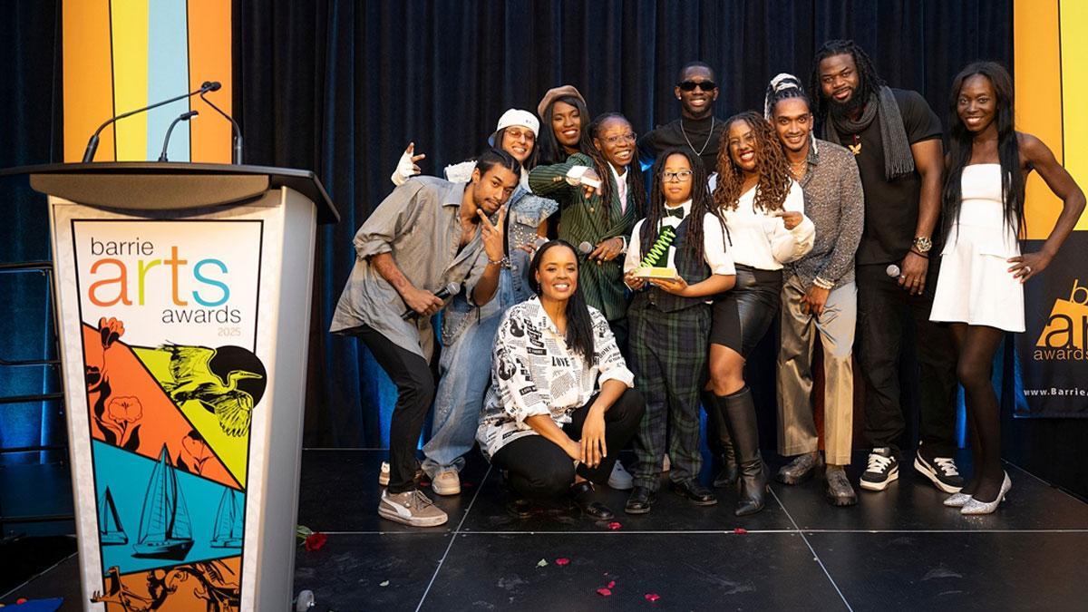 Group of individuals posing together on stage at an awards ceremony.