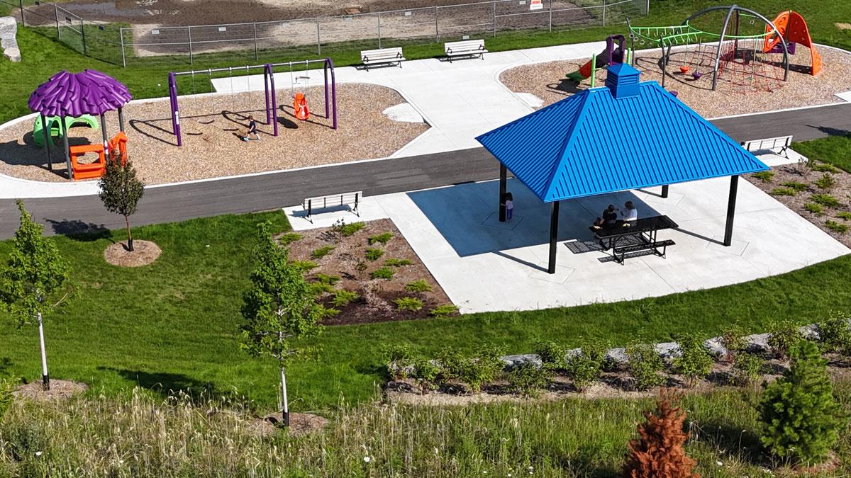 Playground scene with a blue gazebo, swings, and colourful playground equipment.
