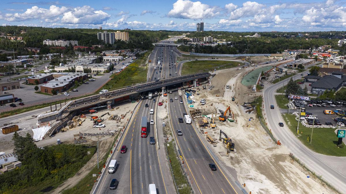 Aerial view of a busy highway under construction with vehicles and machinery present.