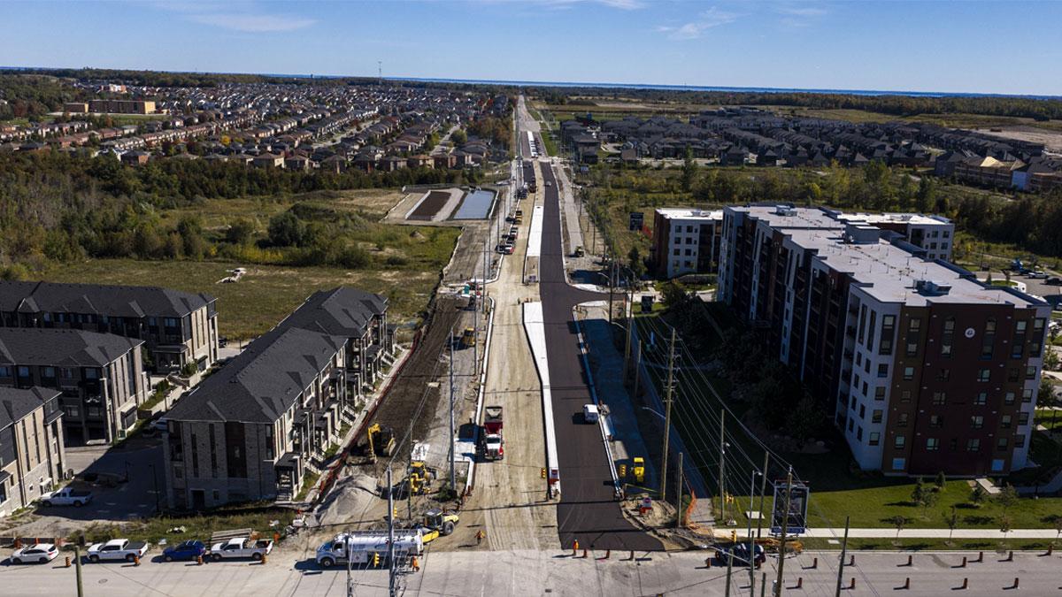 Aerial view of urban development with road under construction, surrounded by residential buildings.