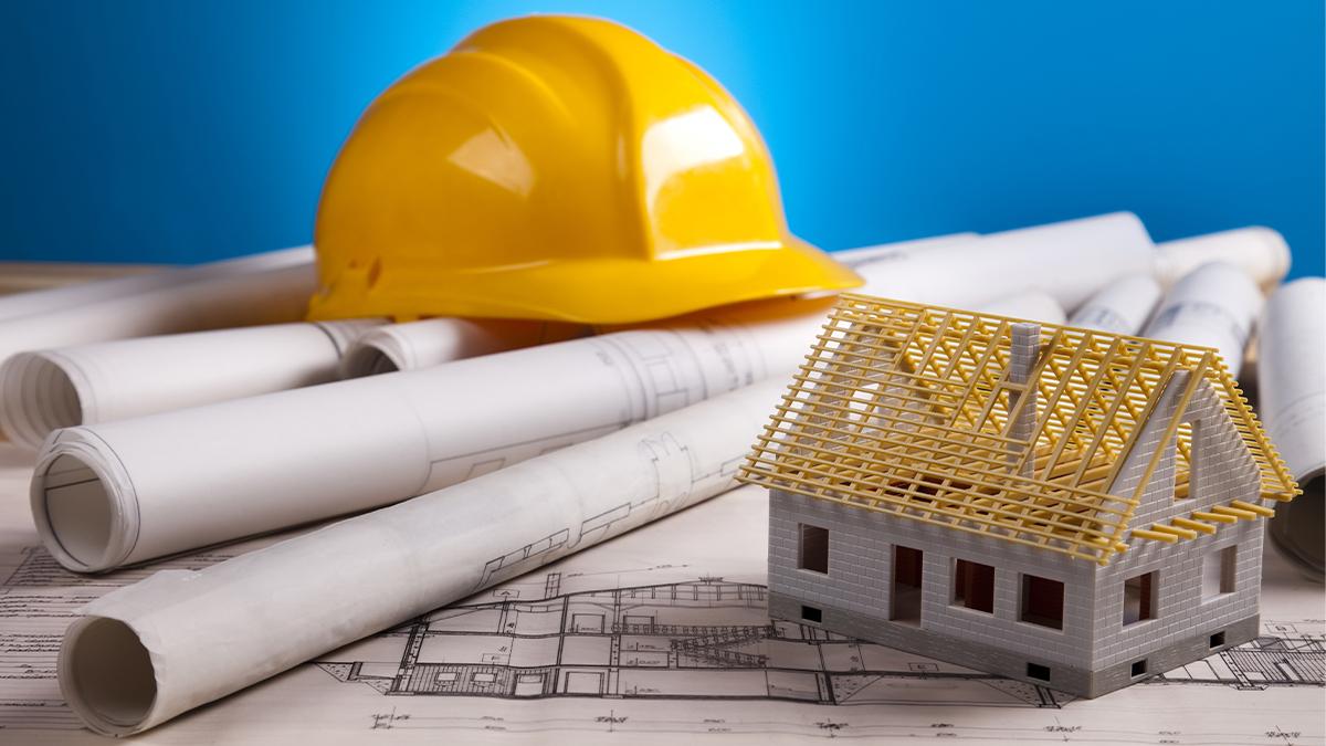 Building plans, hard hat, and model house.