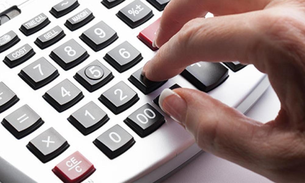 Hand typing on calculator