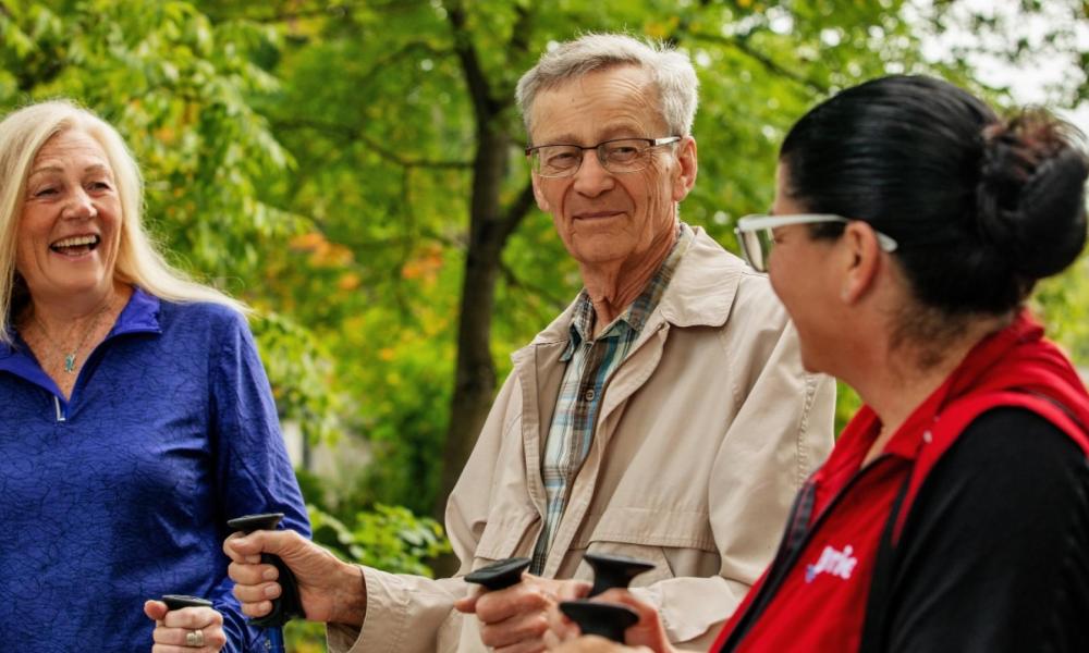 Older adults smiling, trees in background