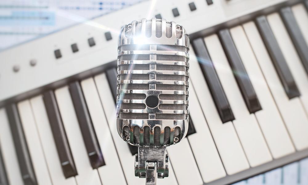 Retro microphone with piano keys and sheet music in background