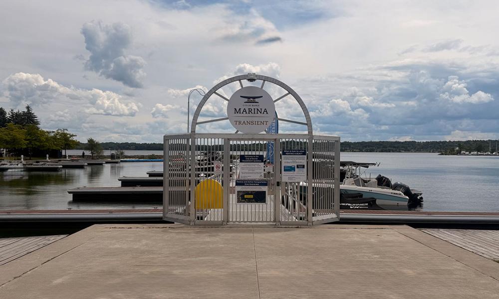 Entrance gate to a marina, with boats docked nearby.