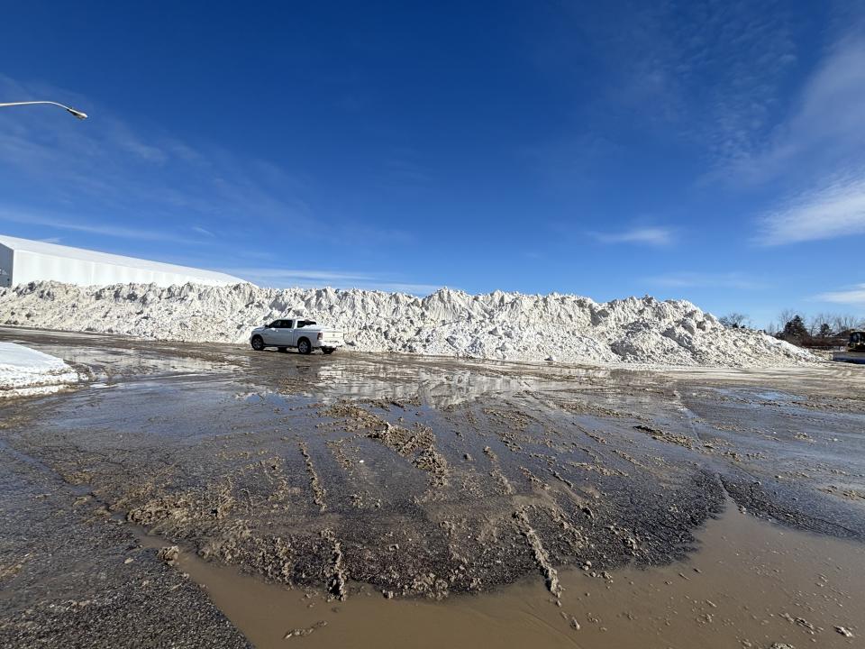 Truck parked in front of large snow pile