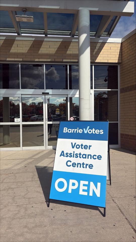 Voter Assistance Centre sign outside a building with "OPEN" displayed prominently.