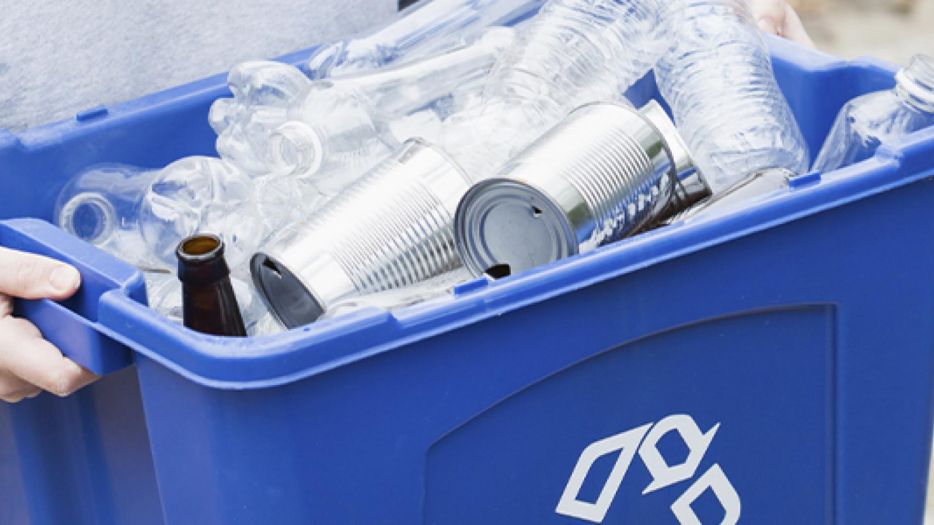 blue recycling bin filled with containers